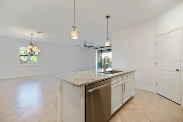 a kitchen with a sink a counter space and a chandelier