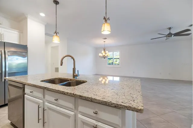 a kitchen with granite countertop a sink a counter top space and cabinets