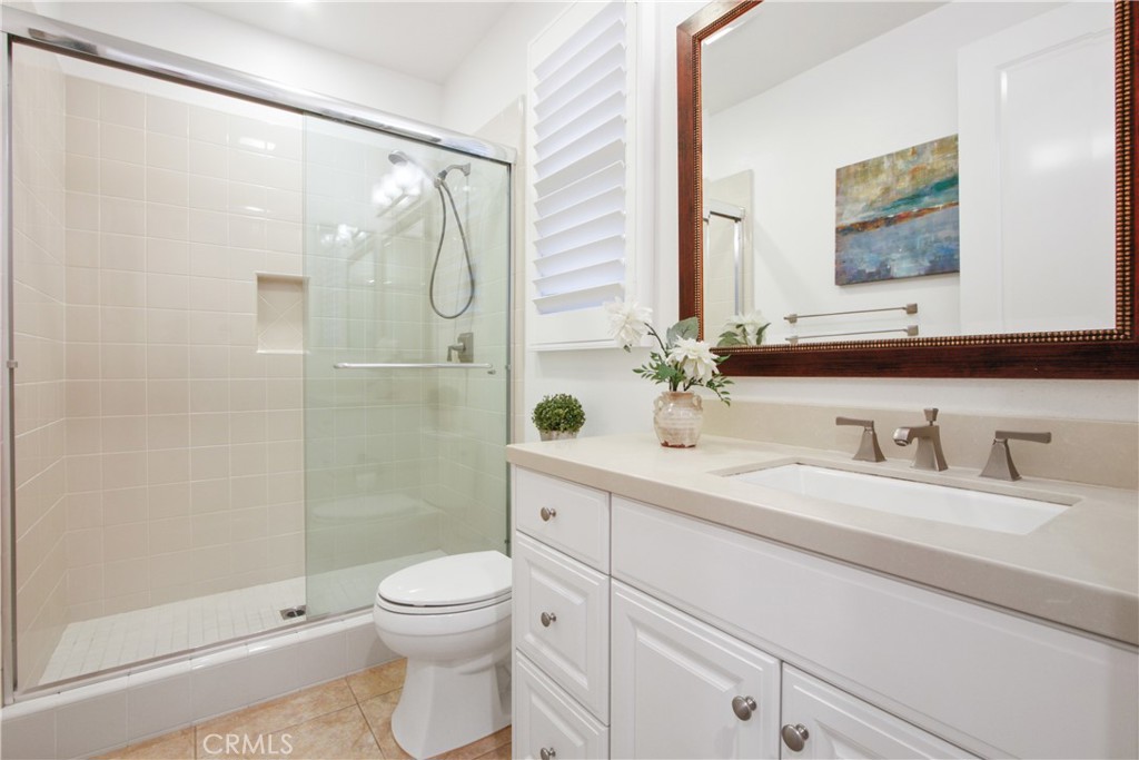 64 Hazelton Irvine, CA 92620 - Photo 19 of 23 a bathroom with a granite countertop sink toilet a large mirror a shower and vanity
