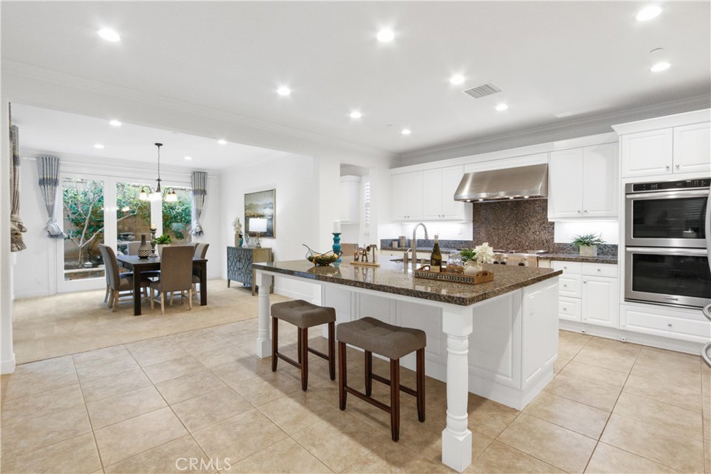 64 Hazelton Irvine, CA 92620 - Photo 6 of 23 a kitchen with kitchen island granite countertop wooden cabinets dining table and stainless steel appliances