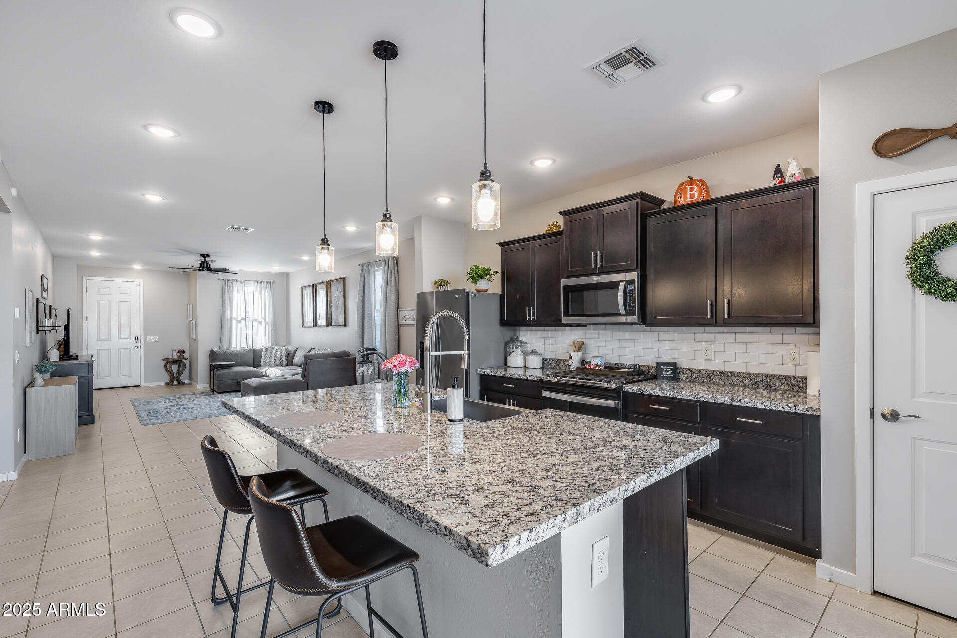 19920 West Rancho Drive Litchfield Park, AZ 85340 - Photo 17 of 49 a kitchen with granite countertop kitchen island cabinets and refrigerator