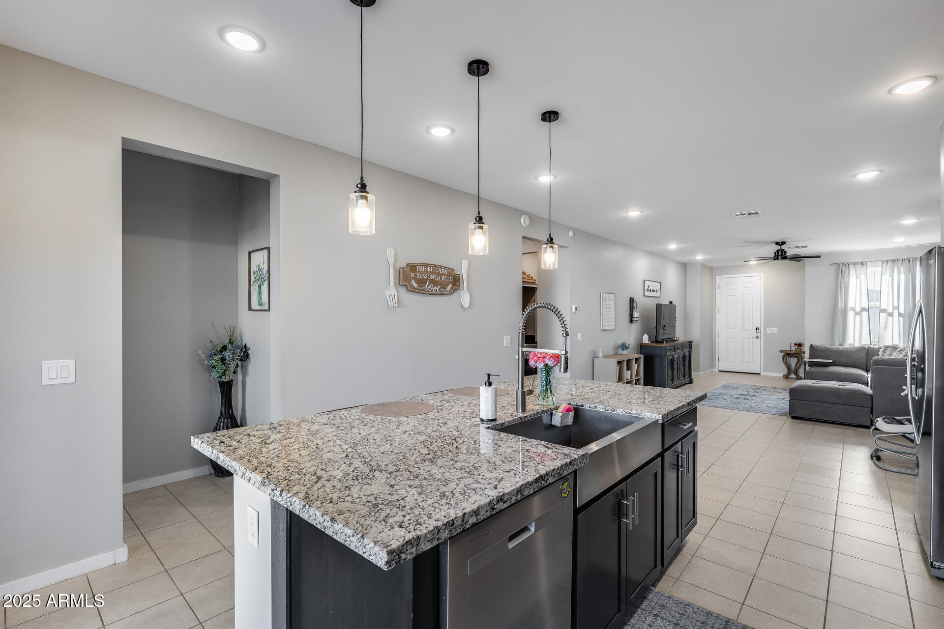 19920 West Rancho Drive Litchfield Park, AZ 85340 - Photo 18 of 49 a kitchen with kitchen island granite countertop a sink a counter top space and living room view