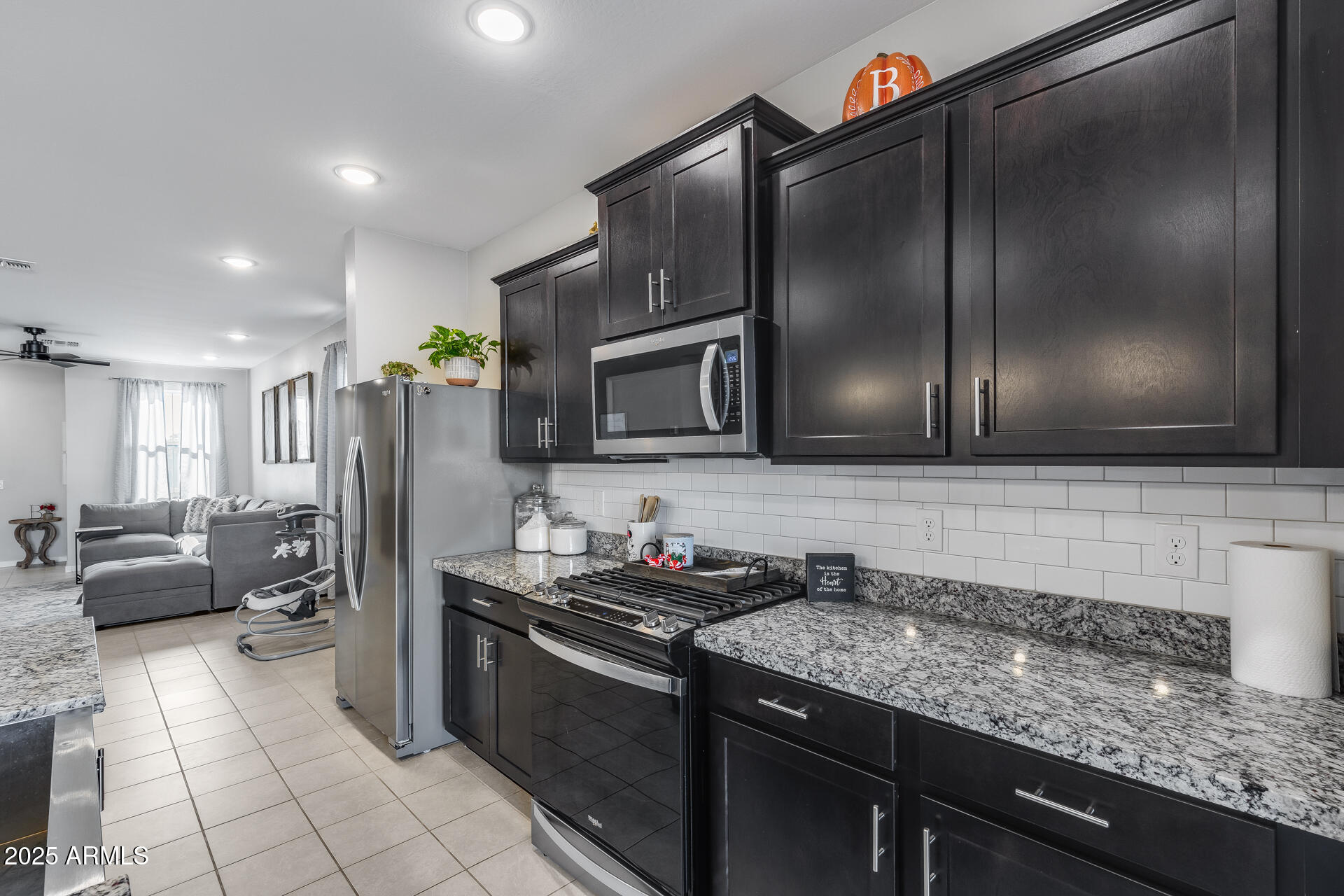19920 West Rancho Drive Litchfield Park, AZ 85340 - Photo 4 of 49 a kitchen with stainless steel appliances granite countertop a refrigerator and a sink