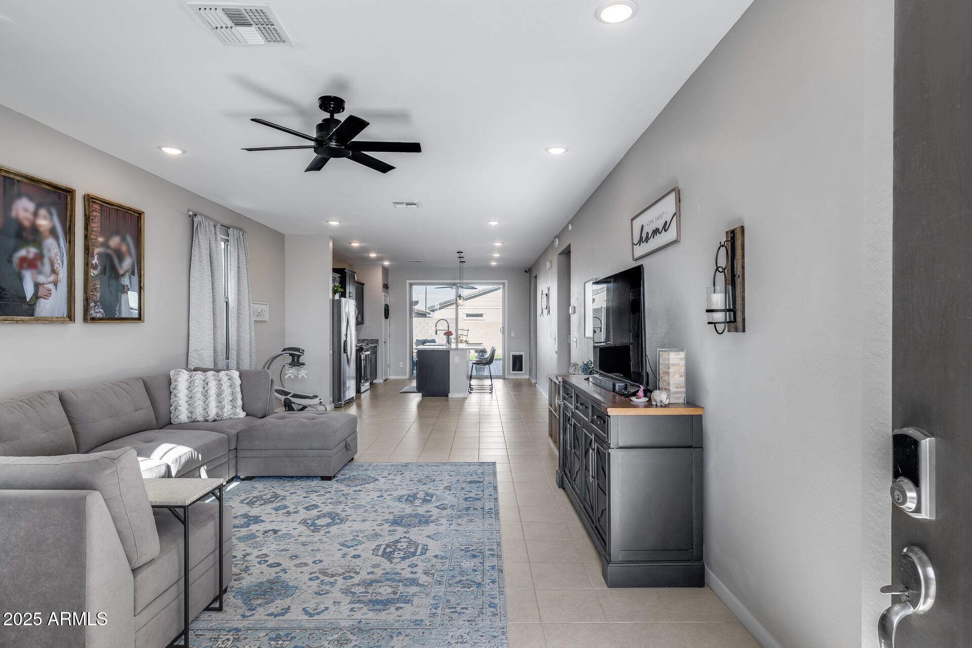19920 West Rancho Drive Litchfield Park, AZ 85340 - Photo 9 of 49 a living room with stainless steel appliances furniture a flat screen tv and a chandelier