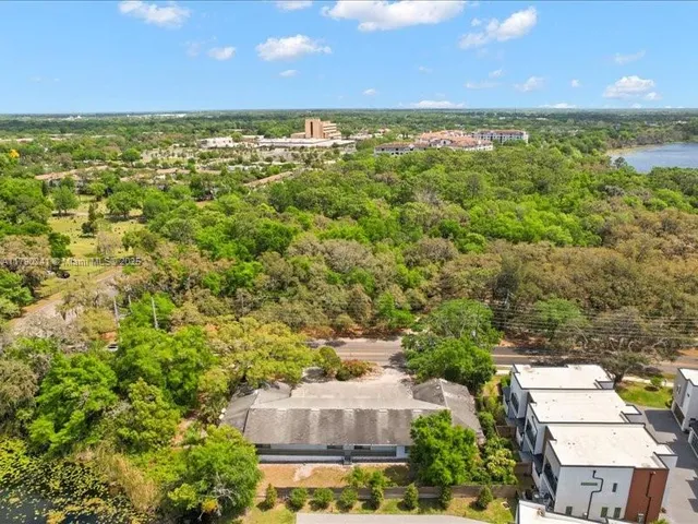 an aerial view of residential houses with outdoor space and trees