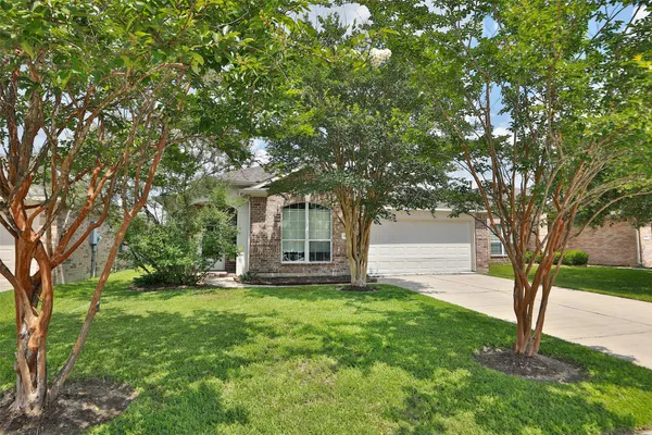 a view of a house with a tree in the grass