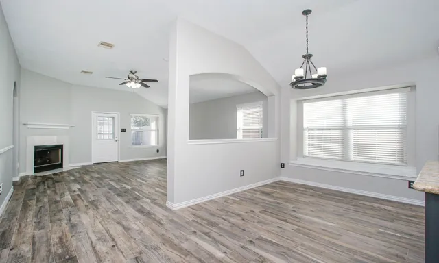 a view of empty room with wooden floor and fireplace