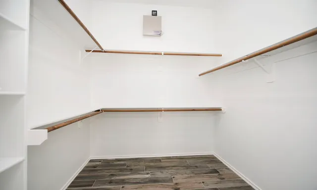 a view of an empty room with wooden floor and entryway