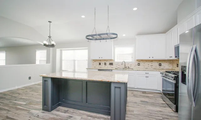 a kitchen with stainless steel appliances granite countertop a sink stove and refrigerator