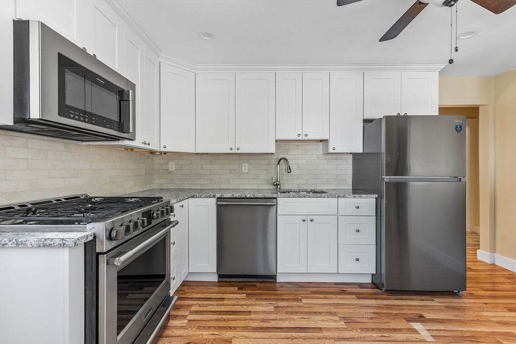 1 Columbia Terrace Dedham, MA 02026 - Photo 5 of 24 a kitchen with granite countertop a refrigerator stove and microwave