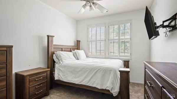 a bedroom with a bed next to a window with a chandelier