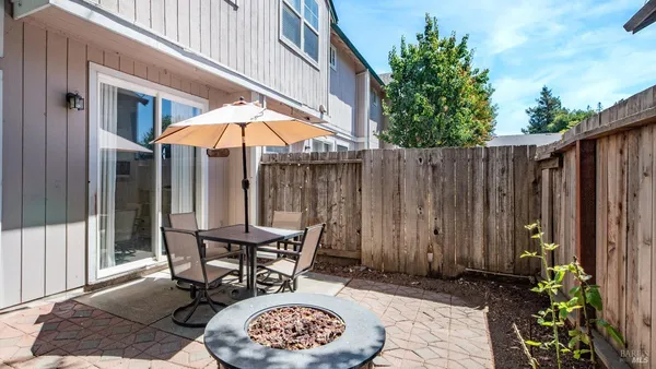 a backyard of a house with table and chairs