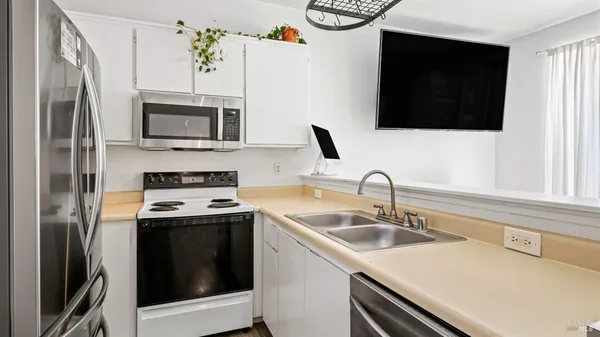 a kitchen with stainless steel appliances a stove microwave sink and refrigerator