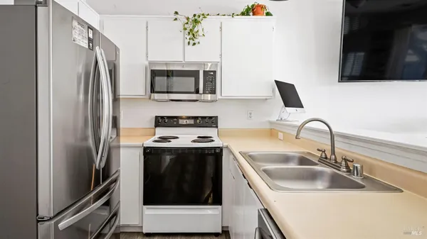 a kitchen with stainless steel appliances granite countertop a refrigerator sink and stove
