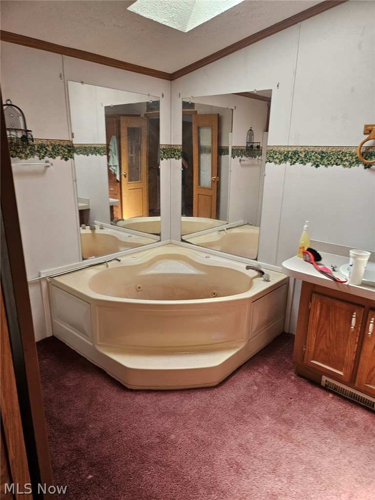 5974 Cleveland Road, Unit 11 Wooster, OH 44691 - Photo 12 of 13 Bathroom featuring a bathtub, ornamental molding, a textured ceiling, and lofted ceiling with skylight
