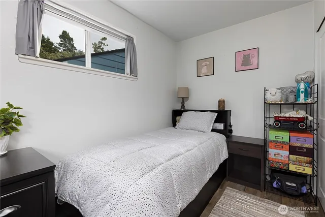 a bedroom with a bed and a potted plant on the dresser