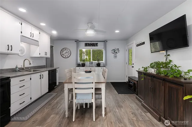 a open kitchen with stainless steel appliances kitchen island granite countertop a table chairs sink and cabinets