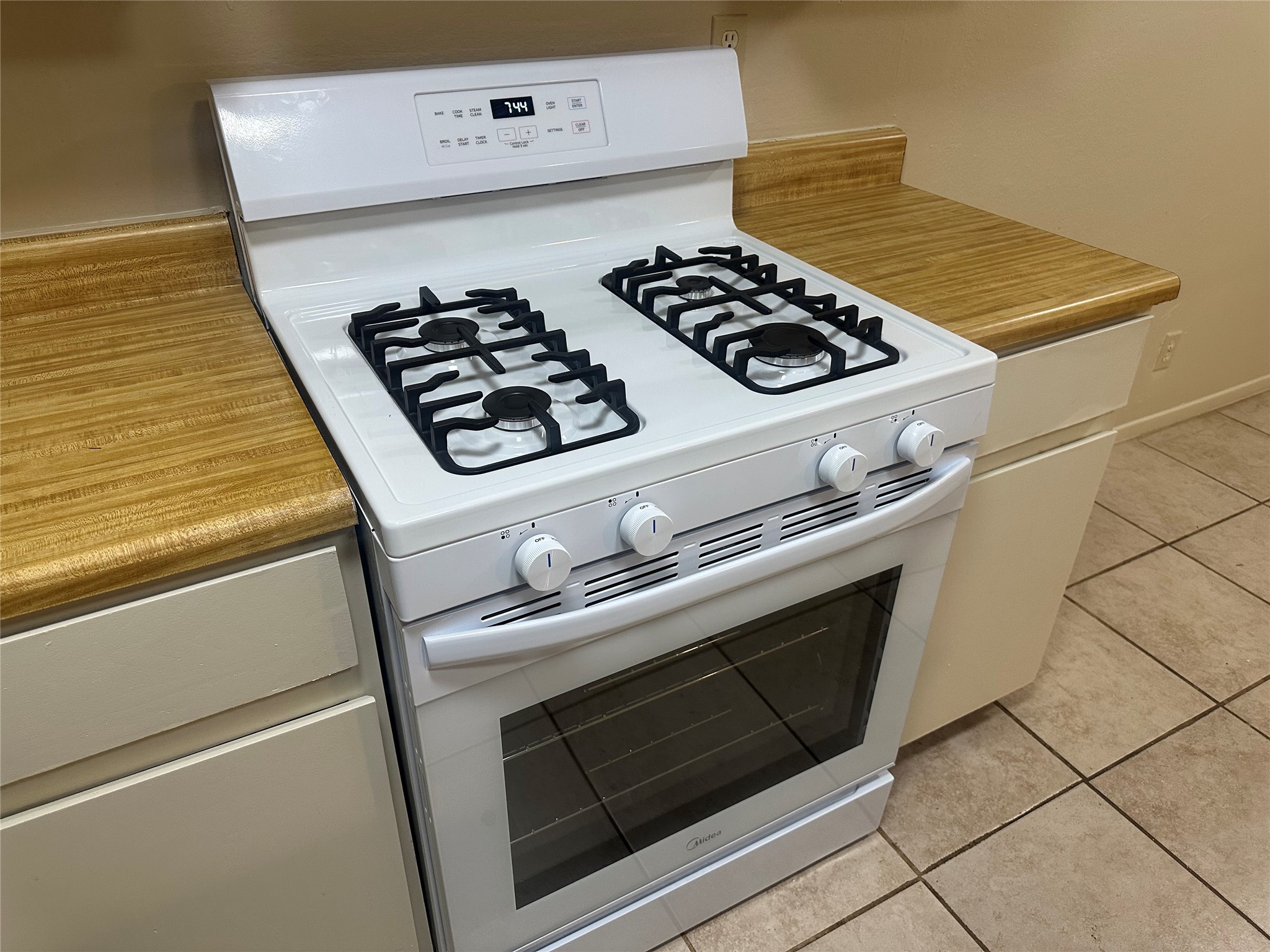 2602 South Bagdad Road, Unit A Leander, TX 78641 - Photo 21 of 26 A well-maintained gas range with four burners, oven, and integrated controls, framed by light wood countertops.