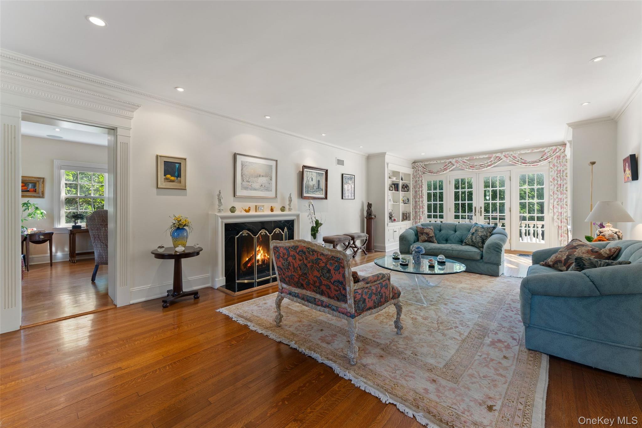 5 Cooper Road Scarsdale, NY 10583 - Photo 5 of 46 Living room with wood burning fireplace and french doors to patio