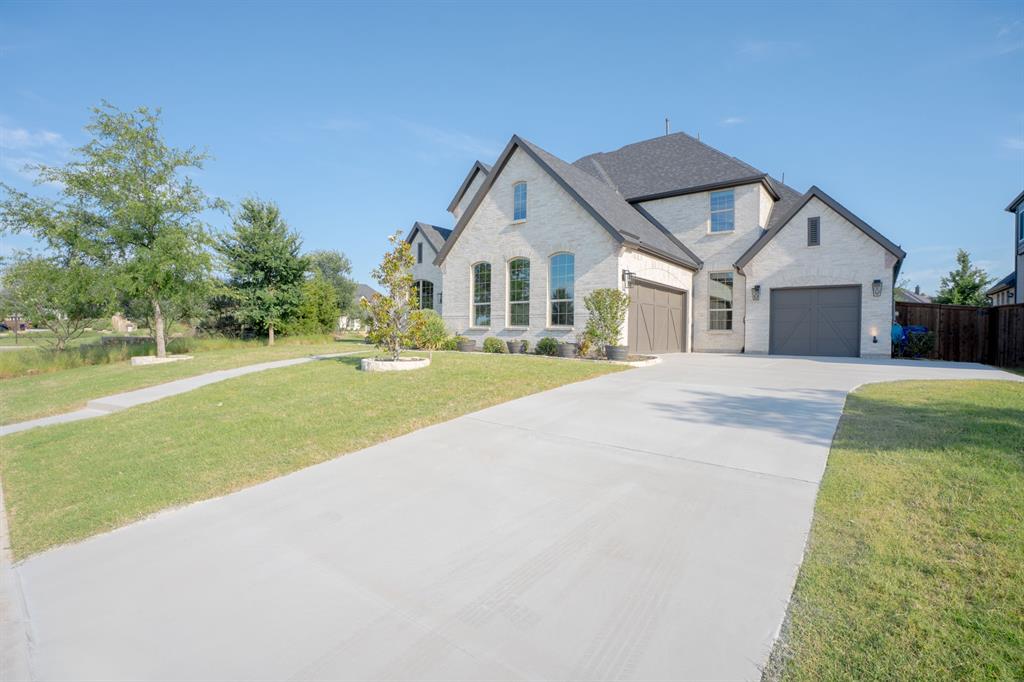 1316 Limestone Ridge Road Mansfield, TX 76063 - Photo 5 of 40 Light brick exterior with dark trim and a two-car garage