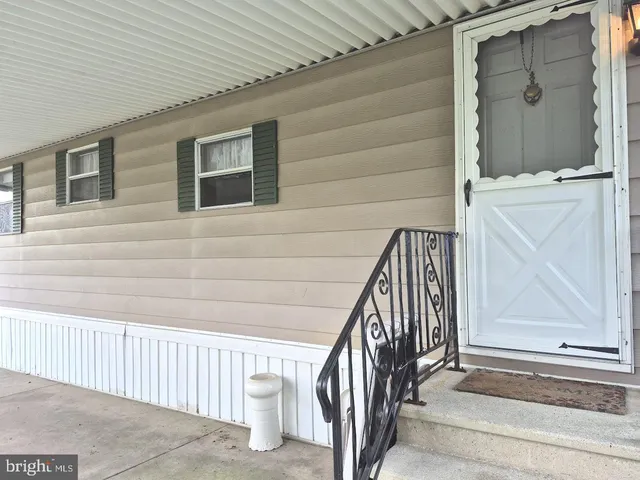 a view of staircase with railing and white walls