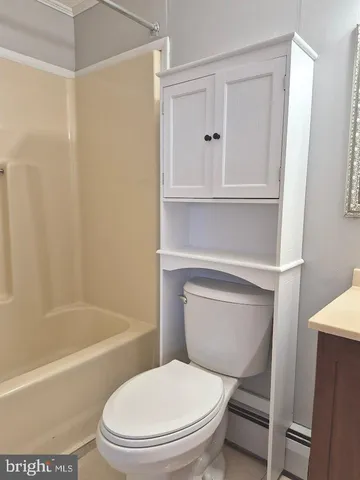 a white toilet sitting next to a bath tub