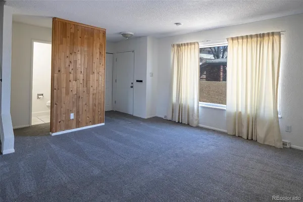 an empty room with windows and closet area
