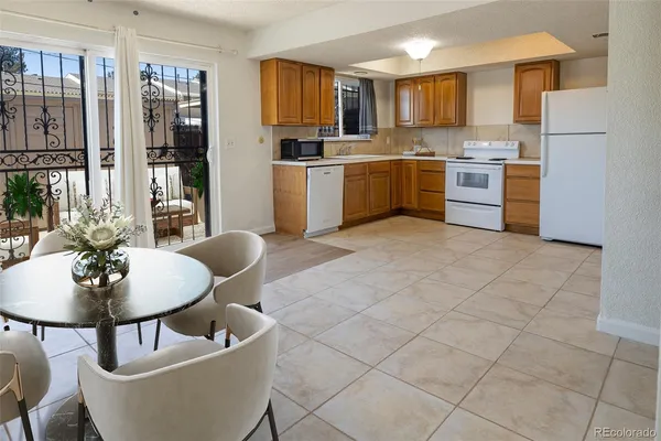 a kitchen with stainless steel appliances granite countertop a sink a stove a dining table and chairs