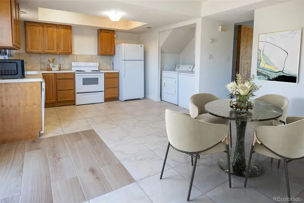 a kitchen with kitchen island a stove a table and chairs in it