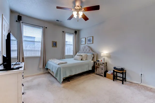 a spacious bedroom with a bed and a chandelier