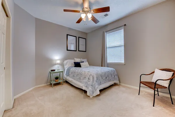 a bedroom with a bed a chair and a chandelier