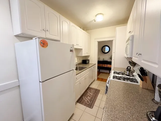 a white refrigerator freezer and a stove sitting inside of a kitchen