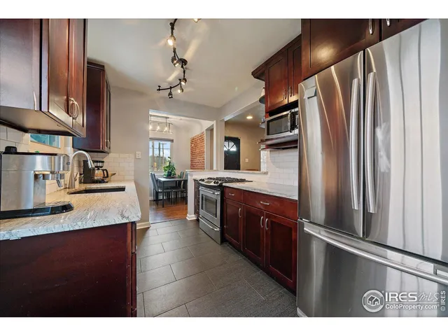 a kitchen with stainless steel appliances granite countertop a refrigerator and a sink