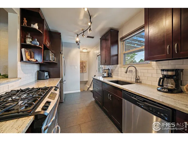 a kitchen with stainless steel appliances granite countertop a sink stove and cabinets