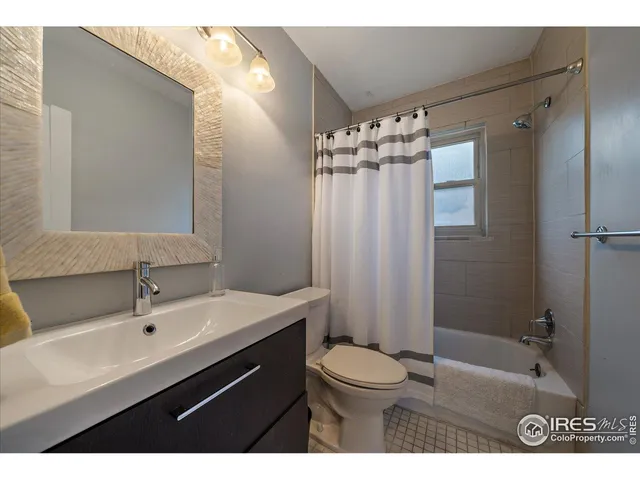 a bathroom with a sink a toilet a mirror and shower