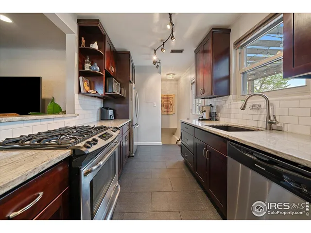 a kitchen with stainless steel appliances a sink stove and cabinets