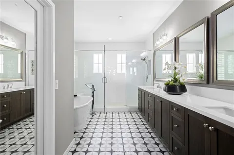 a spacious bathroom with a double vanity sink a large mirror and a shower