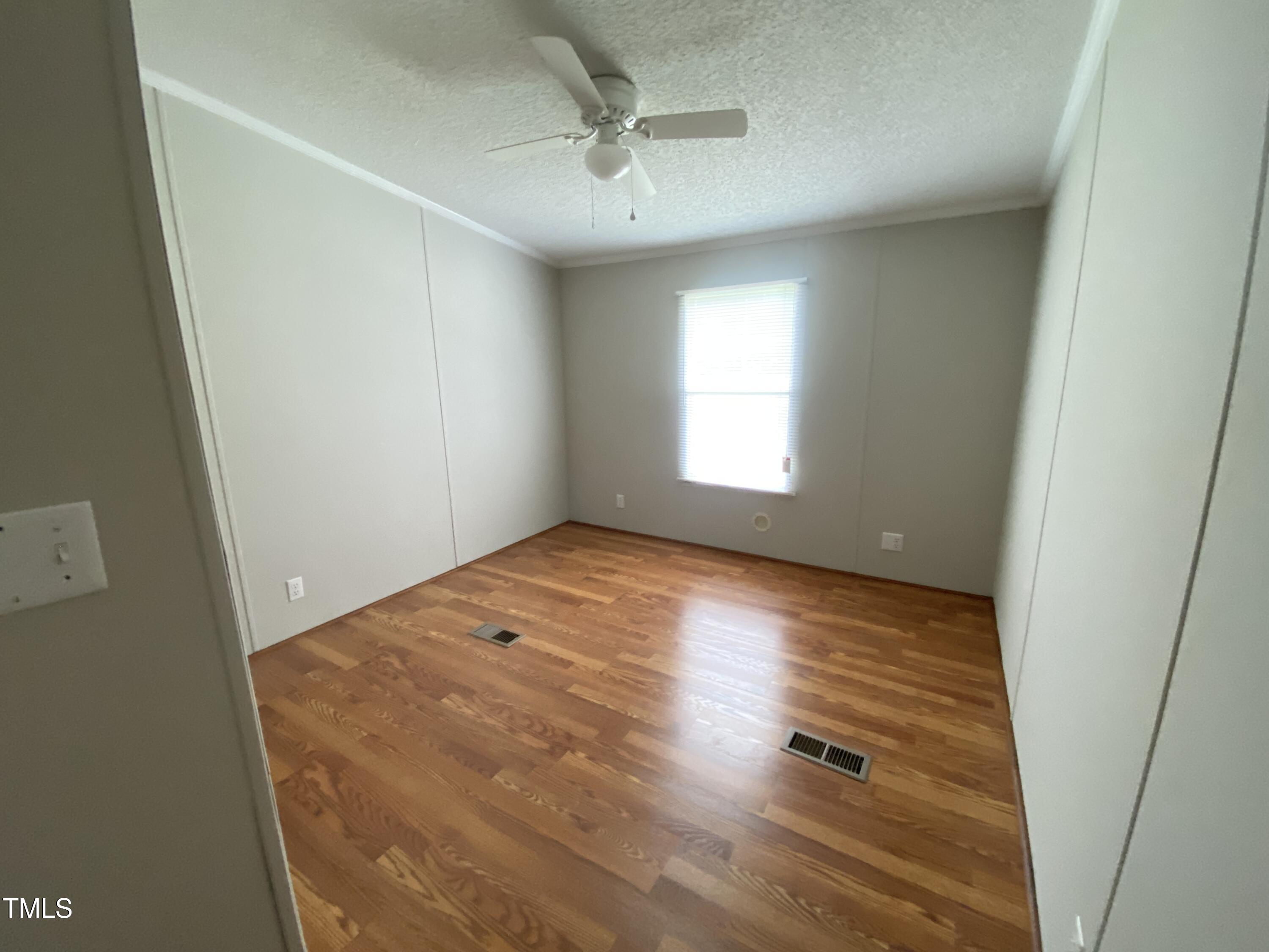 2020 Sanders Road Stem, NC 27581 - Photo 13 of 23 an empty room with a window and wooden floor