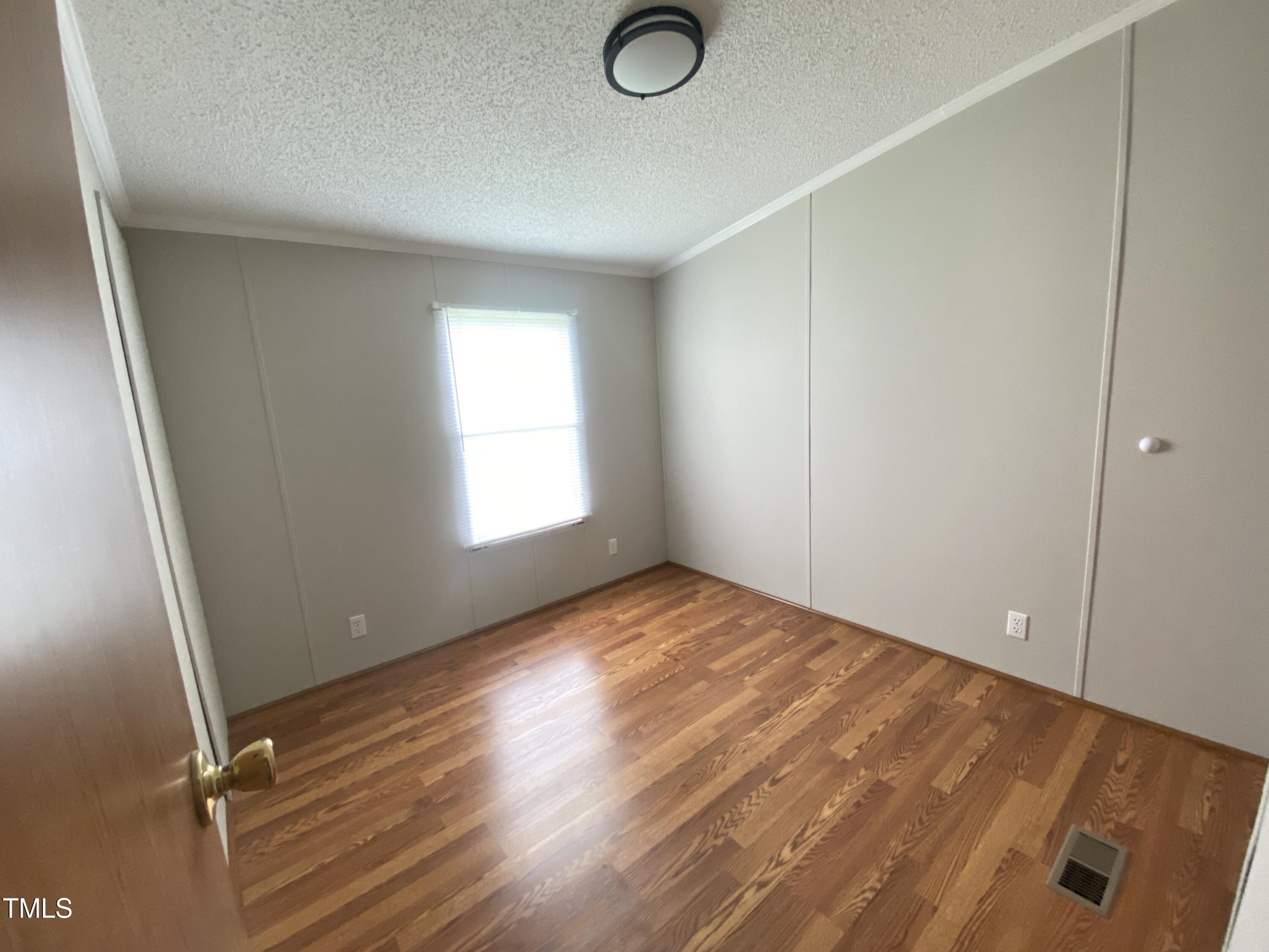 2020 Sanders Road Stem, NC 27581 - Photo 14 of 23 a view of empty room with window and wooden floor