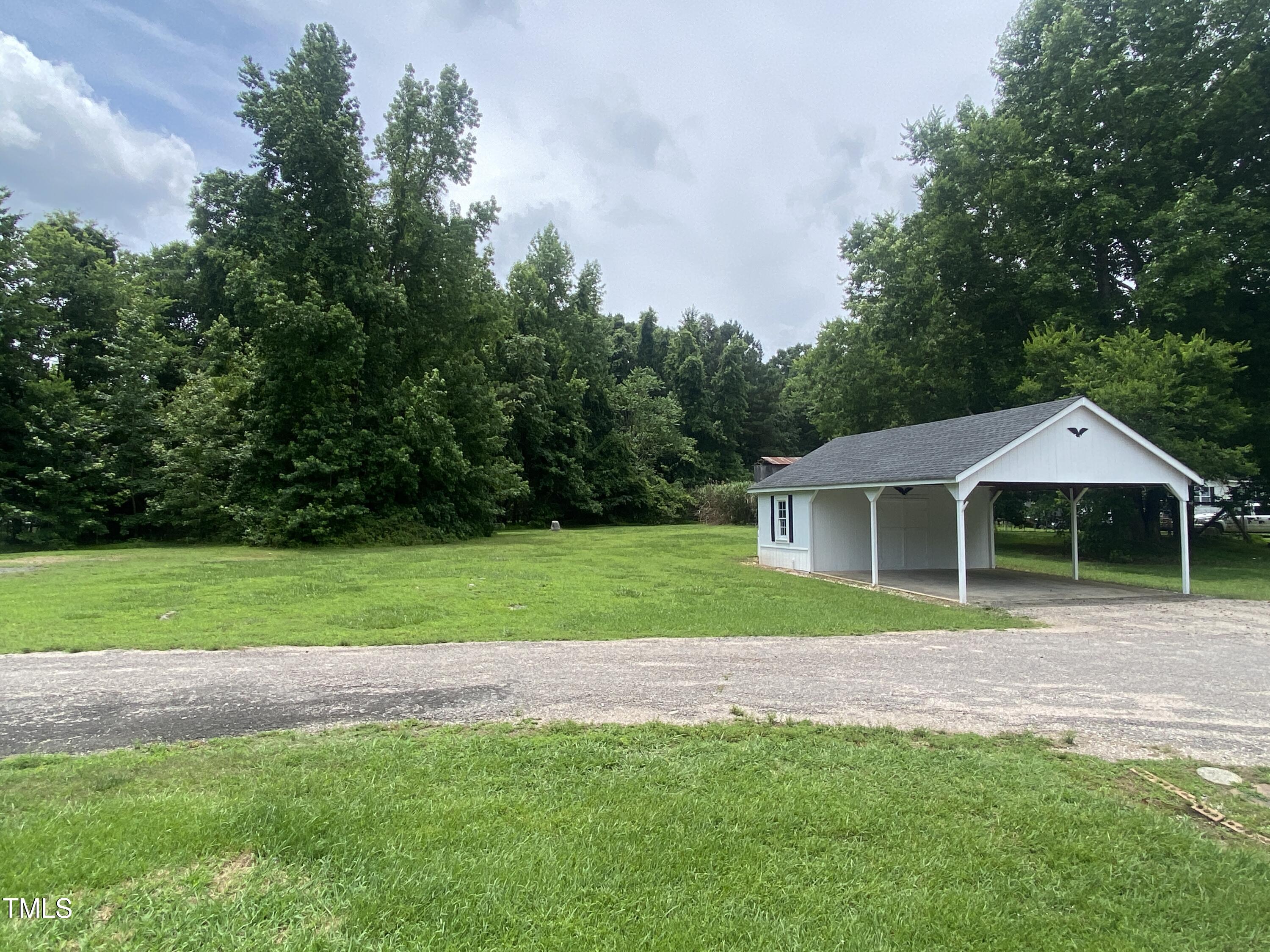 2020 Sanders Road Stem, NC 27581 - Photo 20 of 23 a front view of a house with a garden