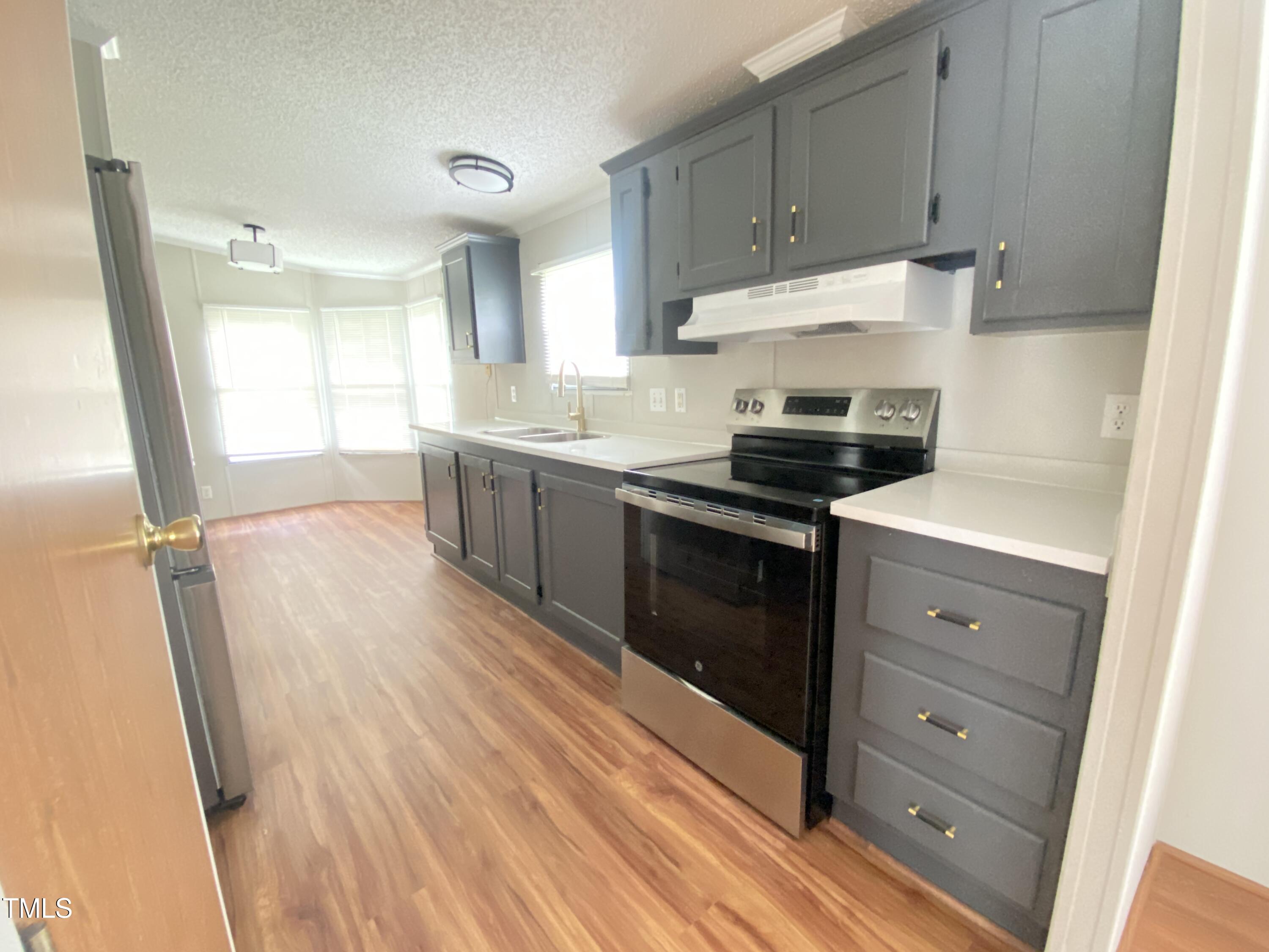 2020 Sanders Road Stem, NC 27581 - Photo 4 of 23 a kitchen with granite countertop white cabinets and white appliances