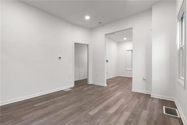 an empty room with wooden floor & closet area