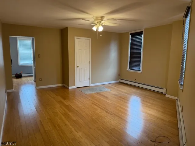 a view of a livingroom with wooden floor and a ceiling fan