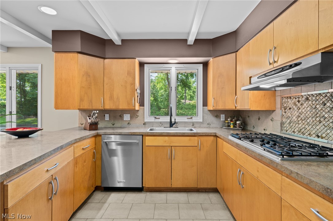 4830 Som Center Road Moreland Hills, OH 44022 - Photo 17 of 48 A perfect kitchen built for the way you cook and gather: a gas stovetop, built-in ovens, and a breakfast island offer everyday function, all beneath warm, beamed ceilings.