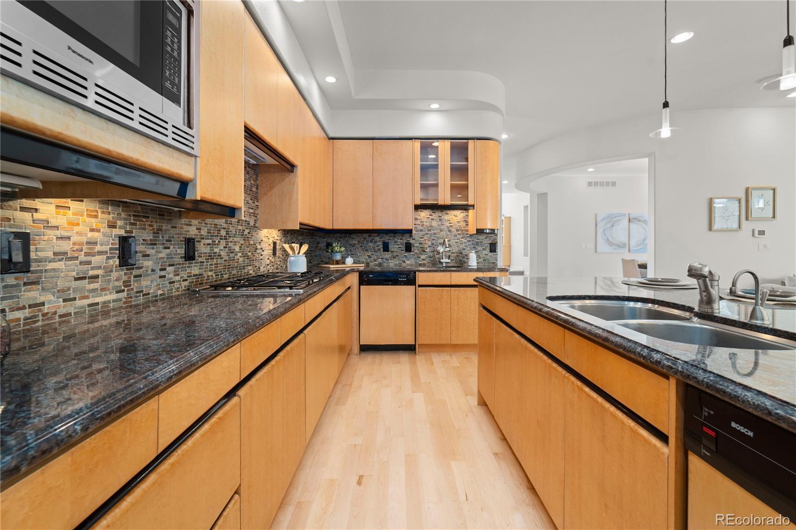 465 Madison Street Denver, CO 80206 - Photo 12 of 40 a large kitchen with stainless steel appliances granite countertop a sink and cabinets