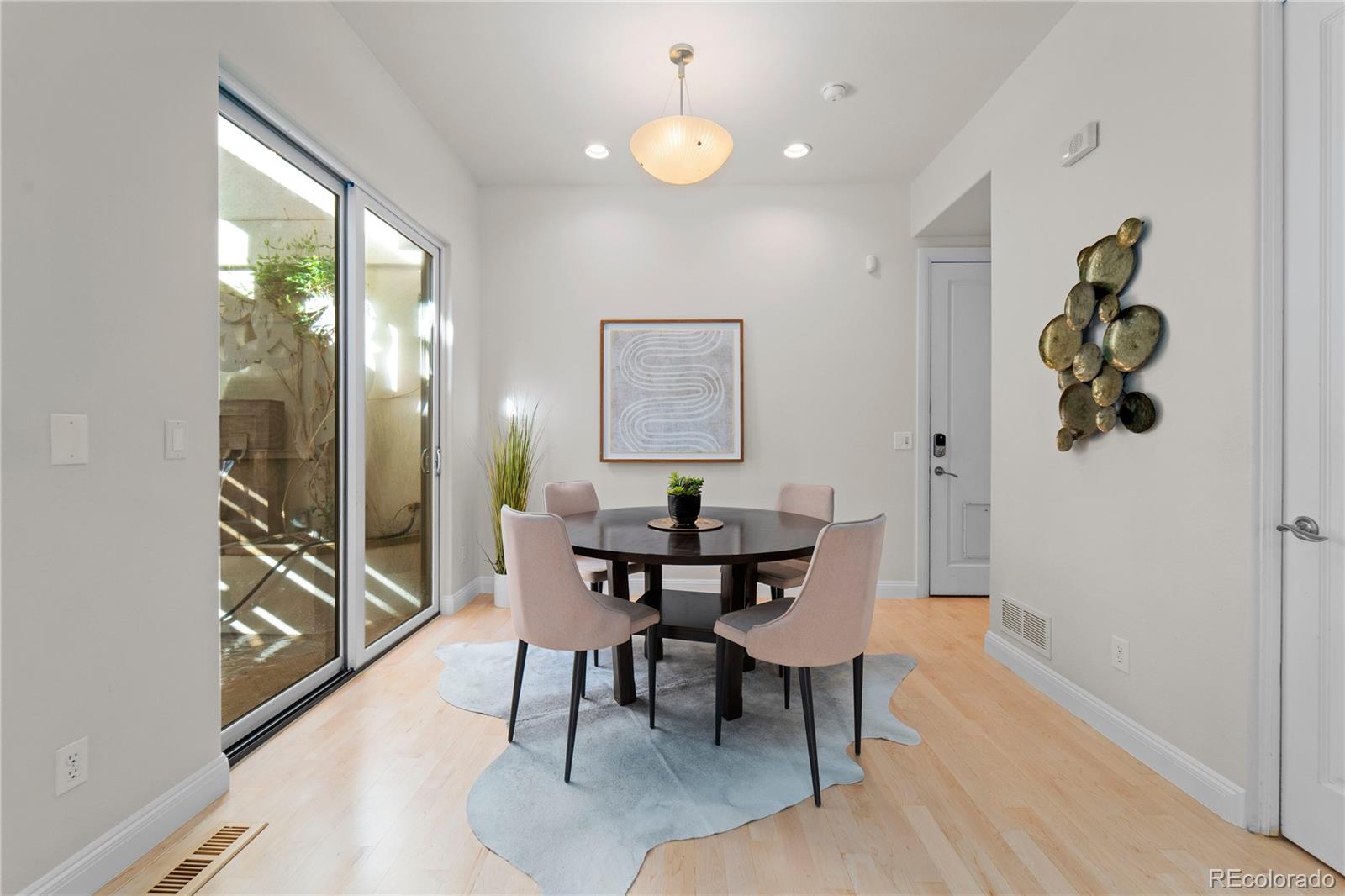 465 Madison Street Denver, CO 80206 - Photo 18 of 40 a view of a dining room with furniture a chandelier and wooden floor