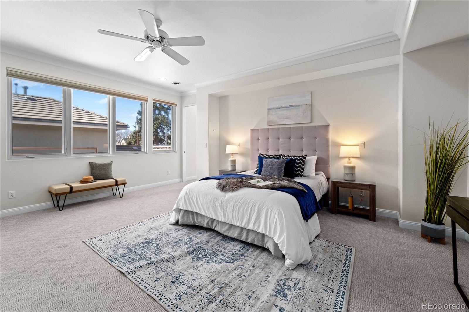 465 Madison Street Denver, CO 80206 - Photo 21 of 40 a spacious bedroom with a bed a couch and a chandelier