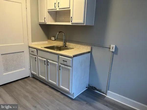 a kitchen with a sink cabinets and wooden floor