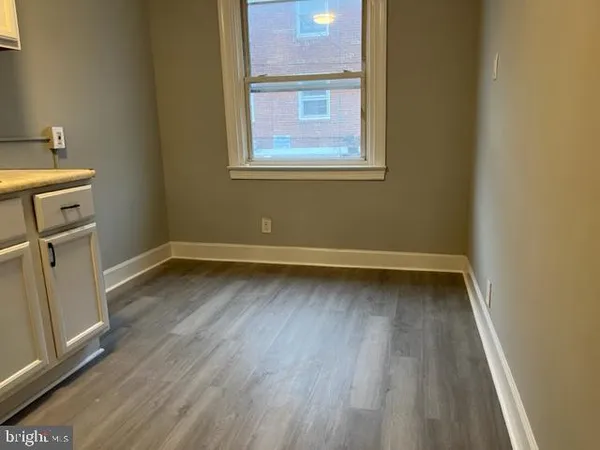 a view of a room with wooden floor and cabinet