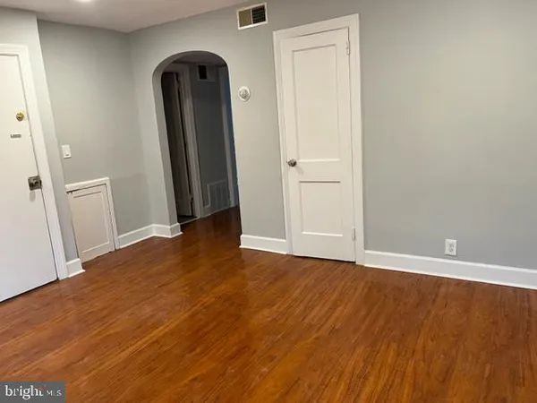 an empty room with wooden floor and closet